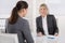 Two business woman sitting at desk: customer and adviser talking