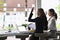 Two business woman waving hand and saying hello to friend or acquaintance.