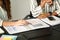 Two business women reviewing financial documents together in office.