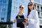 Two business women signing contract outdoors before building of big office center