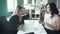 Two business women sitting at table in office discuss topics