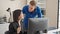 Two business workers using computer high five with hands raised up at the office