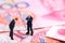 Two businessman standing on the banknote Chinese Renminbi with banknote background