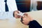 Two businessmen exchanged white business cards on a wooden table