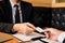 Two businessmen exchanged white business cards on a wooden table in office