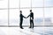 Two businessmen greeting with handshake in office