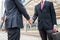 Two businessmen handshaking are dishonest and cheat with holding