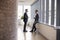 Two Businessmen Having Informal Meeting In Office Corridor