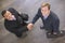 Two businessmen indoors shaking hands smiling