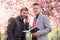 Two businessmen in the park with book and phone