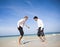Two businessmen Playing Football on the Beach