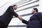 Two businessmen shaking hands outside office build