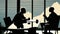 Two businessmen silhouettes negotiation in office across from panoramic window