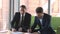 Two businessmen in suits making deal agreement handshake signing contracts