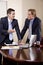 Two businessmen in suits working in boardroom