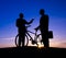 Two Businessmen Talking in Back Lit with Bicycle