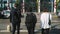 Two businessmen and woman walk across a road