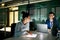 Two businesspeople with computer sitting in an office at desk, working.