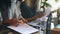 Two businesswomen are actively working on a laptop in a cafe and discussing the work