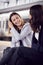 Two Businesswomen Commuting To Work Waiting For Train On Station Platform Talking Together