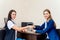 Two businesswomen fist bump in an office