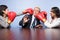 Two businesswomen punching a businessman