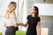 Two Businesswomen Shaking Hands In Modern Office
