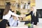 Two businesswomen shaking hands over a desk as they close a deal