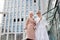 Two businesswomen standing outside with coffee with buildings on background