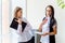 Two businesswomen telling gossip in an office