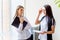 Two businesswomen telling gossip in an office