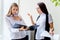 Two businesswomen telling gossip in an office