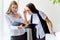 Two businesswomen telling gossip in an office