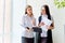 Two businesswomen telling gossip in an office