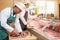 Two Butchers Preparing Meat In Shop