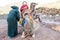 Two camels with berber man owner prepare for long journey.