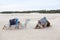 Two camels dromedaries resting on sand