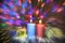 Two candles with clock and Christmas gifts with multi-colored lights on background blurred double focus image
