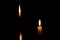 Two candles lighting in a dark room