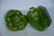 Two capsicum together keep their and the are all green