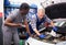 Two car mechanic diagnosing auto engine problem in service