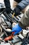 Two Car mechanic engineers checking, fixing the car, making maintenance comprehensive auto check. Auto mechanic charging car