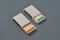 Two cardboard matchboxes of many matchsticks with red and green sulfurs on dark concrete table on kitchen