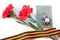 Two carnations, the Order of the Red Star, a military book and St. George ribbon on a white background. Isolated items. 9 may