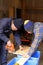 Two carpenters cutting wood with jigsaw in workshop indoor.