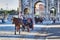 Two carriages transport tourists along Via Dei Fori Imperiali near the famous Arch of Constantine