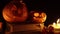 Two carved pumpkins for an autumn mystical feast in smoke closeup on old books