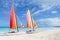 Two catamarans with its colorful sails wide open