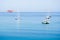 Two catamarans and three sailboats anchored in the middle of the sea