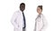 Two caucasian and afro american smiling doctors standing looking in to camera on white background.